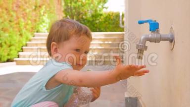 小女孩在<strong>玩水</strong>。 幼儿<strong>玩水</strong>从水龙头流出.. 小孩拿着空的塑料瓶